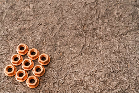 Heap of copper screw-nuts on wooden background. Background. High quality photoの写真素材