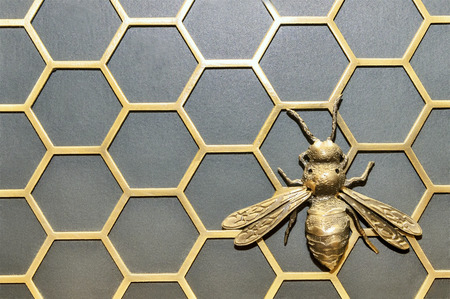 Iron bee on a honeycombの写真素材
