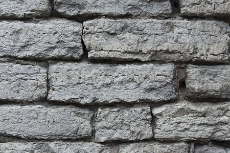 Old grey stone wall background texture close up