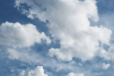 Bright blue summer sky with white clouds backgroundの写真素材