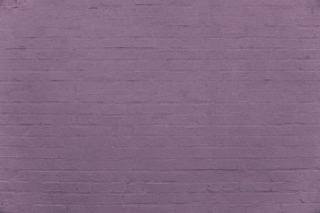 Old dark purple brick wall background texture close upの写真素材
