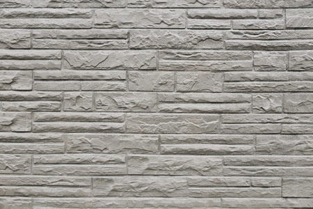 Old grey stone wall background texture close up