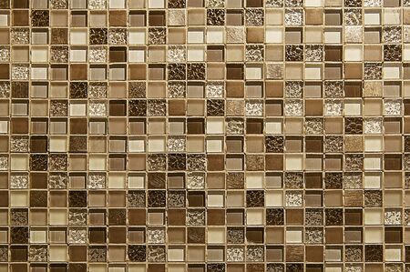 Old brown mosaic wall background texture close upの写真素材