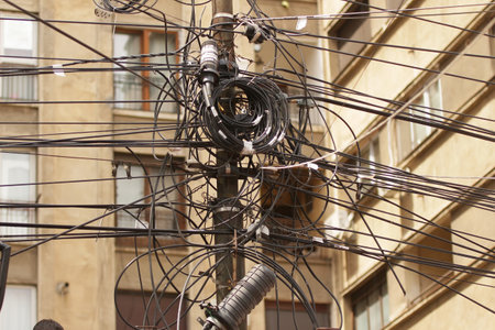 Bucharest, Romania - August 01, 2018: Many electricity, internet and communications cables hang out on a pillar in Bucharest.のeditorial素材