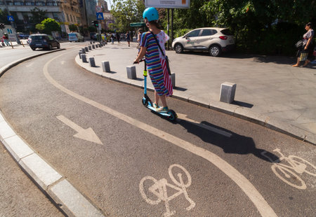 Bucharest, Romania - July 01, 2019: People ride electric scooter on the Victory Avenue bicycle track in Bucharest, Romania.のeditorial素材