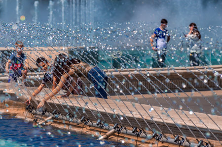 Bucharest, Romania - August 07, 2019: Children have fun with water jets that sprinkle from the fountains in the Unirii Square Park on a hot day in Bucharestのeditorial素材