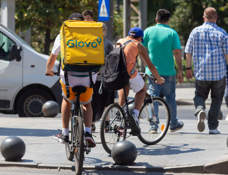 Bucharest, Romania - August 13, 2019: A Glovo food delivery courier delivers food in Bucharest, Romania.のeditorial素材