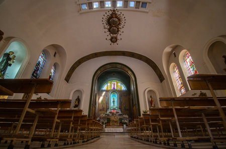 Bucharest, Romania - August 13, 2019: The benches and the altar with the statue of the Virgin Mary are seen inside the Roman Catholic churchのeditorial素材