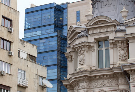 Bucharest, Romania - February 07, 2019: A modern high-rise building in contrast to some old buildings and Grand Hotel Continental (R) located on Victory Avenue in Bucharest, Romania.のeditorial素材