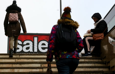 Bucharest, Romania - January 28, 2020: People pass by a billboard on which it is written sale is seen on a street in Bucharest.のeditorial素材