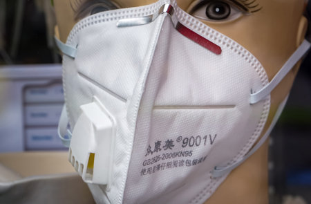 Bucharest, Romania - Mai 04, 2020: A 9001V GB2626-2006KN95 chinese respirator mask with valve that looks like a 3M model is displayed on a mannequin in the window of a medical equipment store.のeditorial素材
