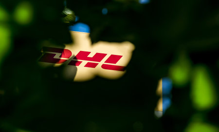 Bucharest, Romania - June 28, 2020 A logo of DHL delivery, courier, parcel, and express mail service company is seen on a street in downtown Bucharest. This image is for editorial use only.のeditorial素材