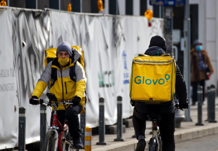 Bucharest, Romania - February 05, 2021: Two Glovo food couriers delivers food in Bucharest, Romania.のeditorial素材
