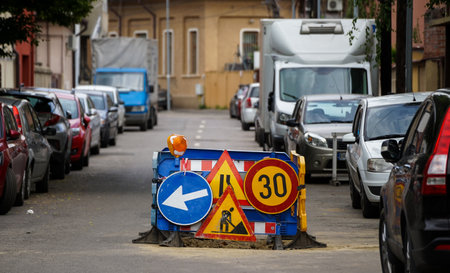 Bucharest, Romania - May 24, 2021: Several traffic signs warn of the existence of a construction site for repairing a road.のeditorial素材