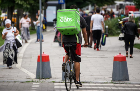 Bucharest, Romania - June 08, 2021: An Uber Eats food delivery courier delivers food in Bucharest, Romania.のeditorial素材