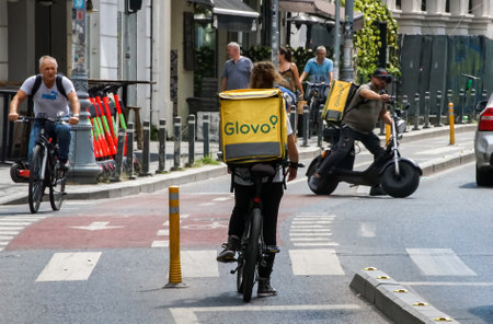 Bucharest, Romania - August 12, 2021: Glovo food delivery couriers delivers food in Bucharest, Romania.のeditorial素材