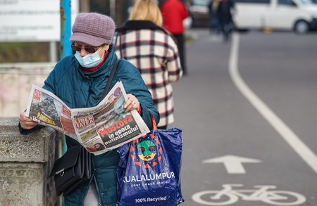 Bucharest, Romania - February 02, 2022: "Moscow in the Age of Putinism" is the headline on the front page of the newspaper Libertatea, which a woman reads.のeditorial素材