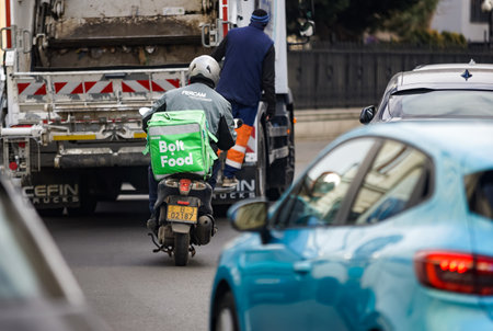 Bucharest, Romania - January 27, 2022: An Bolt Food food delivery courier on a scooter.のeditorial素材