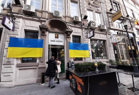 Bucharest, Romania - March 09, 2022: Ukrainian flags hung on the walls of Grand Cafe Van Gogh in the Old Town in solidarity with the Ukrainian people hard hit by the war waged against them by Russia.のeditorial素材