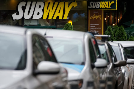 Bucharest, Romania - June 18, 2021: The logo of a Subway fast food restaurant it can be seen above the parked cars in downtown Bucharest.のeditorial素材