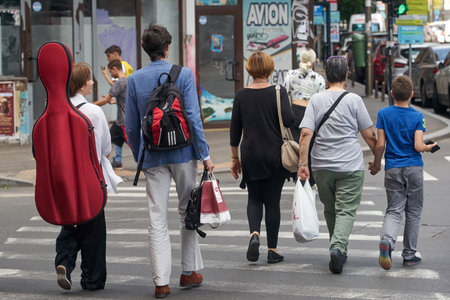Bucharest, Romania - June 17, 2022: Young people walks on a crosswalk near the National University of Music Bucharest.のeditorial素材
