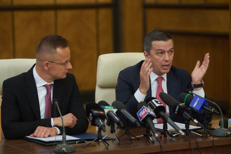 Bucharest, Romania. 4th Apr, 2023: Peter Szijjarto, left, The Minister of Foreign Affairs and Foreign Trade of Hungary, listen to the speech of Sorin Grindeanu, the Romanian Minister of Transport, during the signing ceremony of the agreement between the Gのeditorial素材