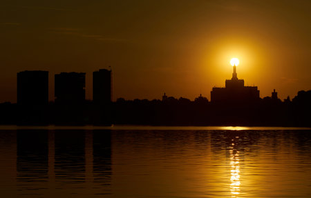 Bucharest, Romania - June 09, 2023: Sun sets overlapping over the top of House of the Free Press, building unfortunately inspired by Lomonosov Moscow State University plans during the communist eraのeditorial素材