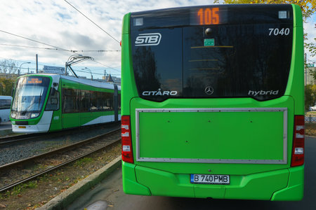 Bucharest, Romania - 5th Sep, 2022: A public transport bus Mercedes Citaro Hybrid is driven near an ASTRA Imperio Metropolitan, Romanian double articulated tram with low floor.のeditorial素材