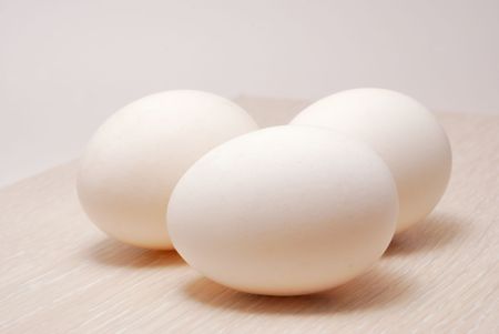 Three eggs on white tinted woodの写真素材