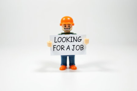 toy man holding a sign with the text (I'm looking for a job) on a white backgroundの素材