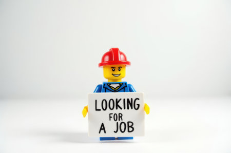toy man holding a sign with the text (I'm looking for a job) on a white backgroundの素材
