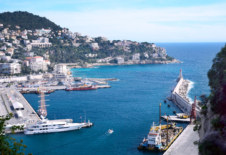 Nice, France, March 2019. Port of the French city of Nice. Private yachts and boats are parked near the coast. Beautiful mountains, the port, the lighthouse and the turquoise sea - a great place to relax.のeditorial素材