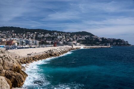 Nice, France, March 2019. Panorama. Azure sea, waves, English promenade and people resting. Rest and...