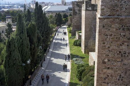 Malaga, Spain, February 2019.  The fortress of Alcazaba  is an Arab fortification on Mount Gibralfaro in Spanish Malaga. Powerful brick walls of the fortress of Malaga on a warm sunny day.のeditorial素材