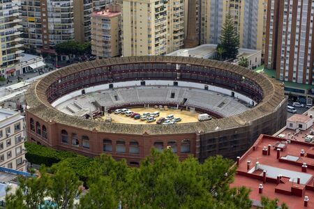 Malaga, Spain, February 2019. La Malagueta (Spanish. Plaza de toros de La Malagueta) - bullring on Reading Boulevard.  Buildings, port, bay, ships and mountains against a cloudy sky.のeditorial素材