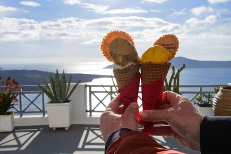 Delicious chocolate and mango ice cream in waffle cups against the background of the sea and...