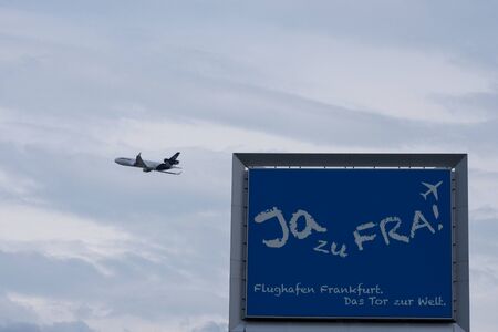 Germany, Frankfurt am Main, June 2019. Airplane in the sky among the clouds. A large white cargo plane takes off before a thunderstorm. Large billboard against the sky. The journey has begun.のeditorial素材