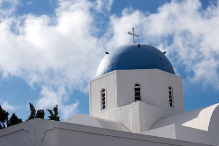 Beautiful island of Santorini, Greece. White Church with a blue dome in the village of Oia on the island of Santorini. Greek journey. The famous blue domes of Santorini.の写真素材
