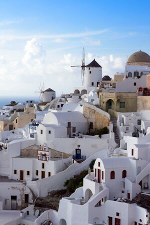 Santorini, Greece. White traditional Greek houses on a hillside on the island of Santorini. Sunset in the Greek city of Oia on the famous island. An amusing trip.の写真素材