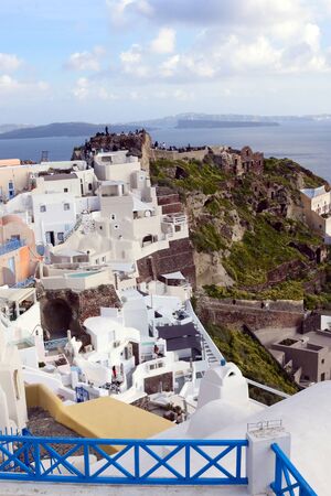 Santorini, Greece, April 2019. White traditional Greek houses on a hillside on the island of Santorini. Tourists are waiting for sunset. Sunset in the city of Oia, Santorini.のeditorial素材