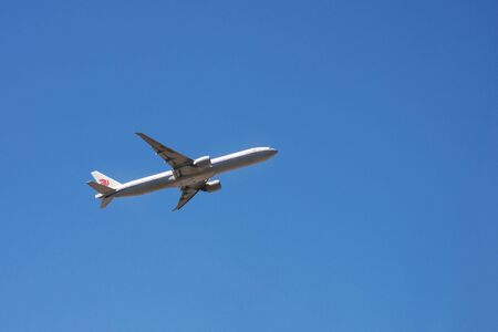 Porto, Portugal, June 2019. White passenger airliner of the Chinese airline Air China against a blue sky. Travel by plane.のeditorial素材
