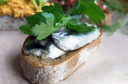 Crispy toasted bread with different fillings. Toast with hummus, salted fish, tomatoes, feta cheese...