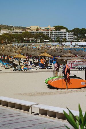 Palma Nova, Mallorca, July 2019. Wide sandy beach on the island of Mallorca in the early morning. Multi-colored surfboards in the resort of Palma Nova. Relax. Balearic Islands.のeditorial素材