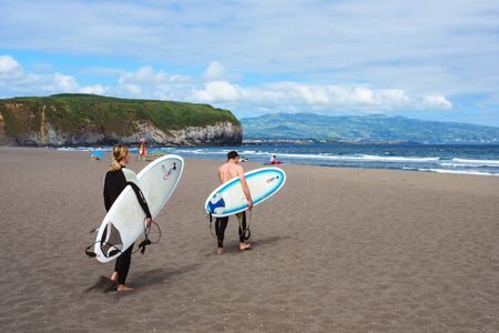 San Miguel, Portugal, June 2019. A man and a 
are skating on a surfboard. Beautiful beach of Praia do Areal de Santa Barbara, San Miguel, Azores. Ideal place for surfing and bodyboarding.のeditorial素材
