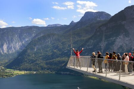 Hallstatt, Austria, September 2019. Tourists take pictures on the Skywalk platform. Beautiful landscapes from the observation deck in the Austrian village of Hallstatt, lake and mountains.のeditorial素材