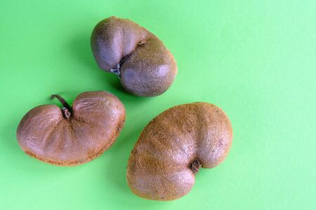Ugly vegetable organic kiwi on a green background.  Horizontal orientation.の写真素材