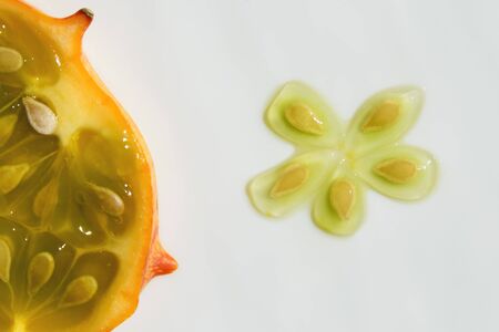 Slice and seeds of kiwano, exotic vegetable cucumis metuliferus closeup. Soft focus. Vegetarian...