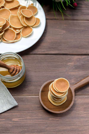 Cereal Pancakes. American gorgeous pancakes in a white plate and honey on an old wooden table. Tasty...