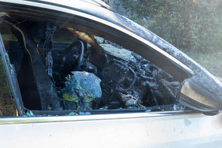 Burnt-out passenger car. Burnt car interior close-up. Fire in the car. Danger.