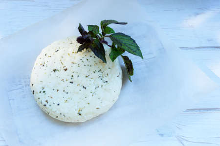 Fresh salted Levantine halloumi cheese and a sprig of basil on a white background. Traditional Cypriot cuisine.の写真素材
